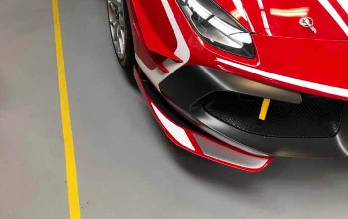 A red Ferrari parked while sitting on a grey epoxy resin floor coating